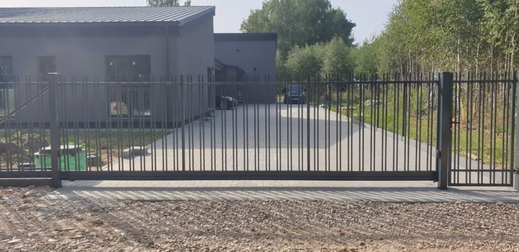 Namai su juodais metaliniais klasika vartais.